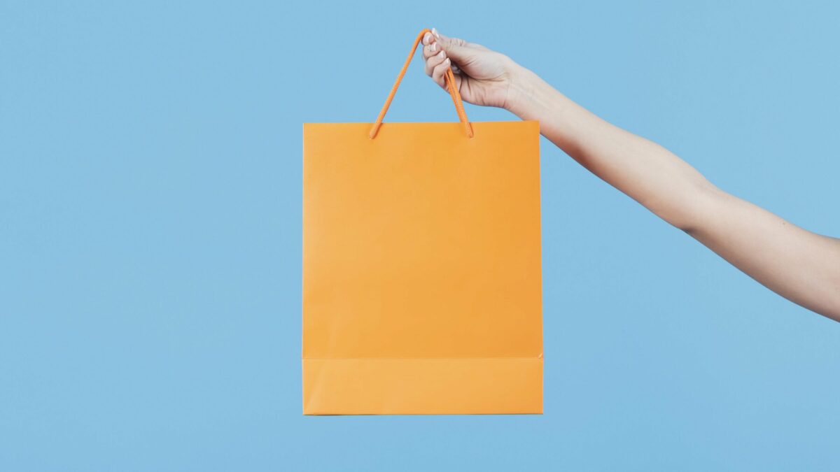 holding a yellow shopping bag